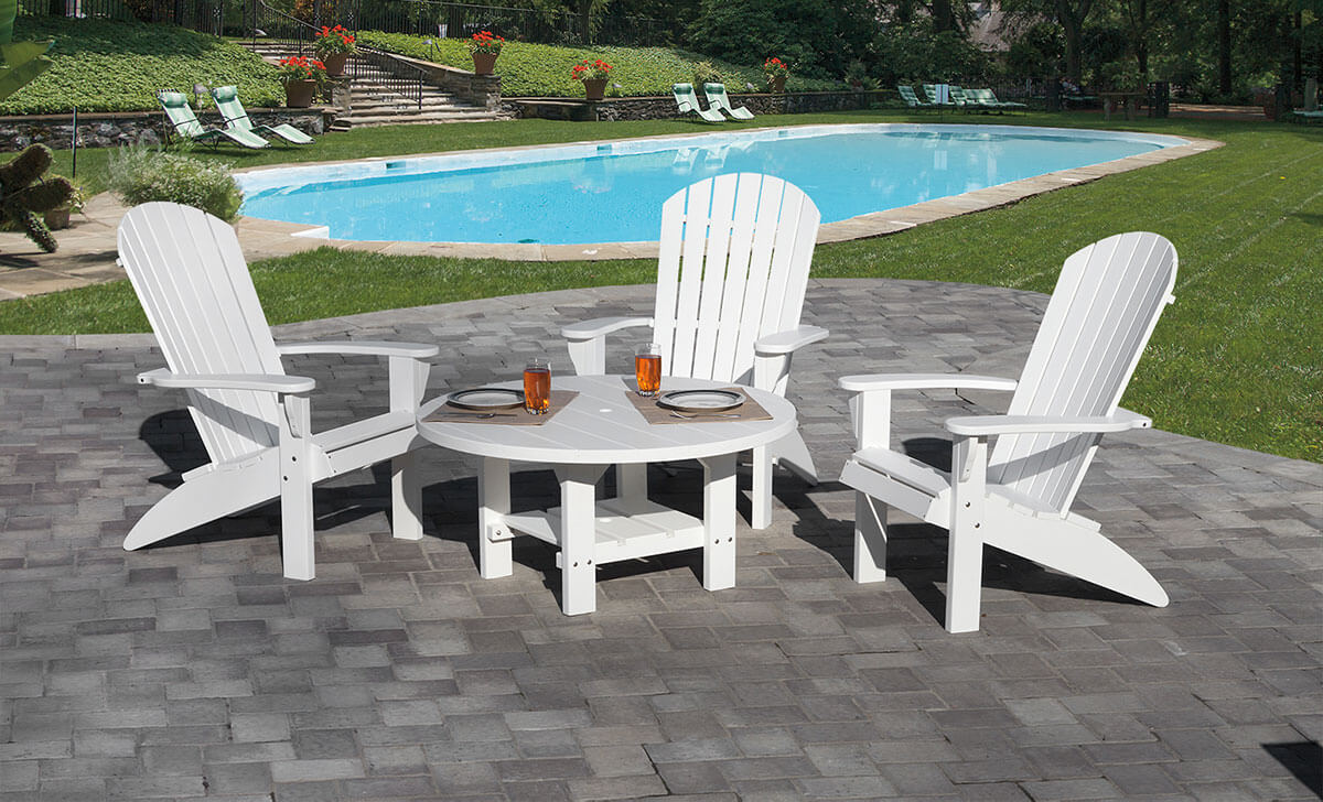 White poly round conversation table on a paver patio