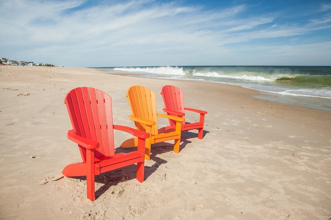SeaAira child's chair Three child-sized Adirondack chairs on the beach.