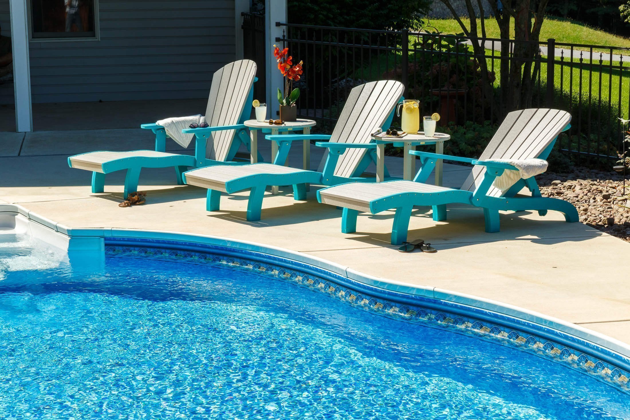 Adirondack chaise Adirondack chaise with arms by the pool.