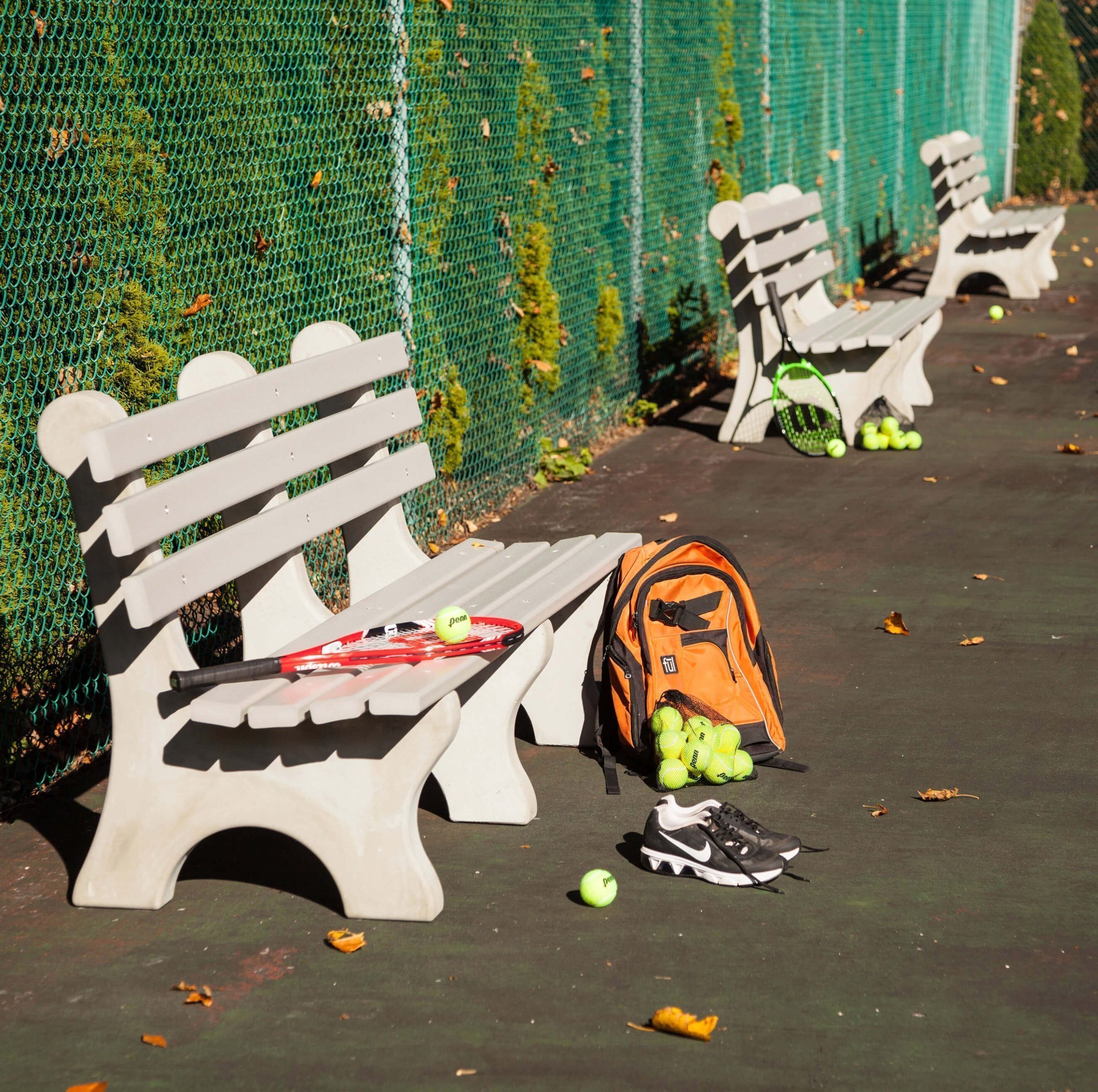 Bench Benches along the perimeter of a tennis court.