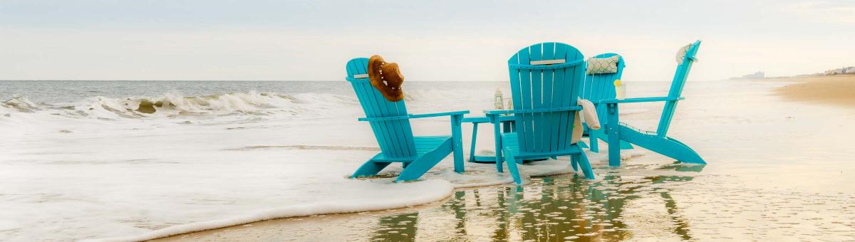 Finch Adirondack and Lounge Finch Adirondack chairs in turquoise on the beach.
